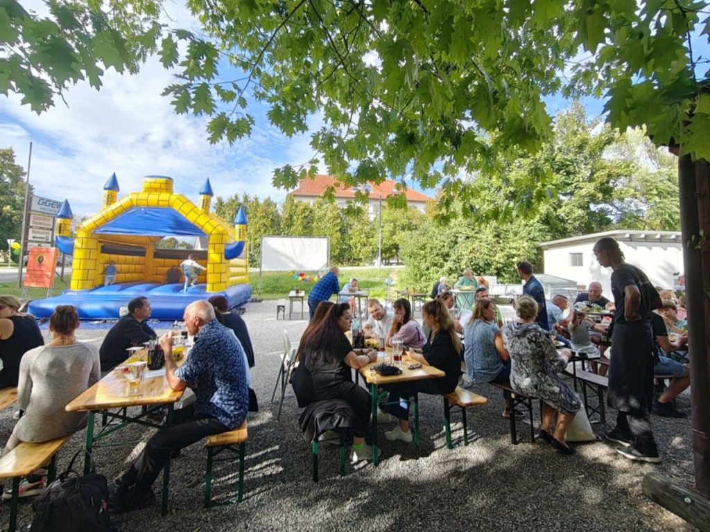 Kinder beim Schminken und Spielen an der Hüpfburg während der Jubiläumsfeier.